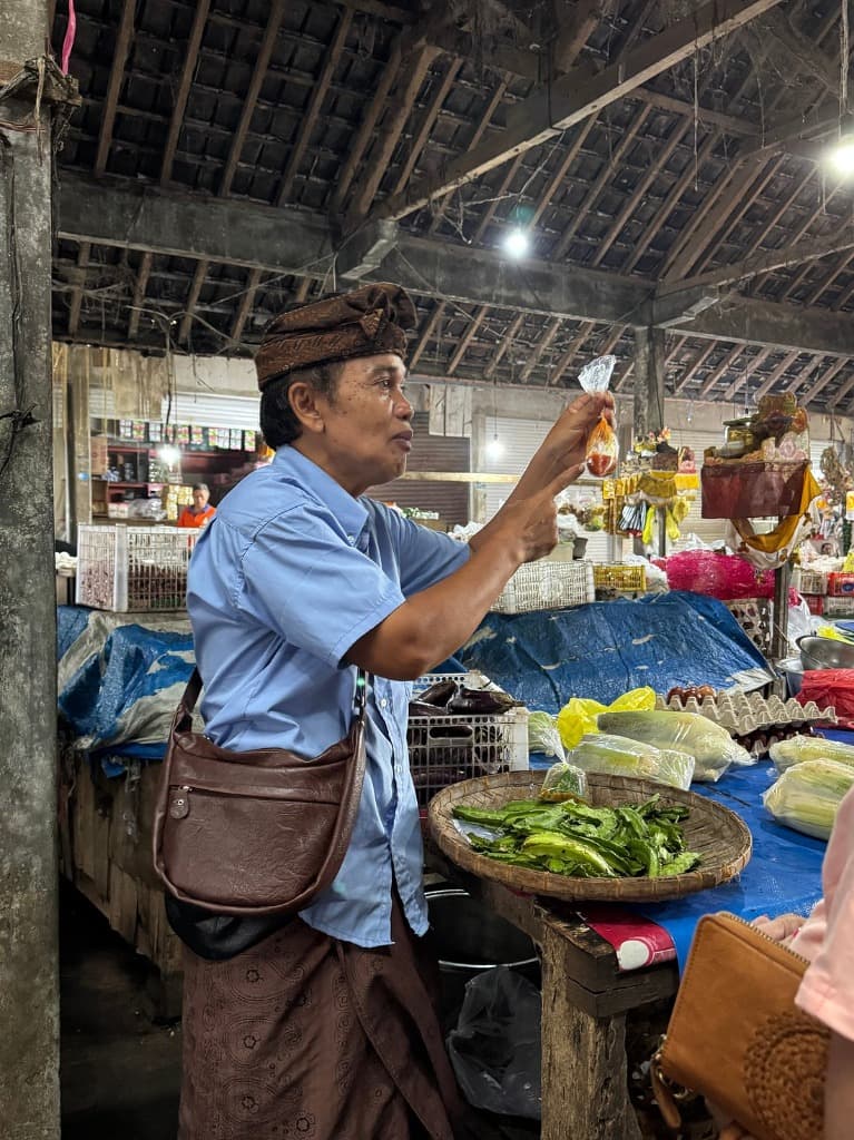 Local guide explaining fresh market ingredients in Pejeng